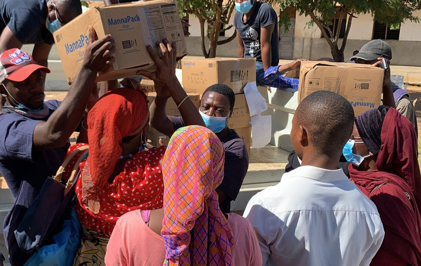 A woman in Mozambique receives a box of FMSC food from relief workers.