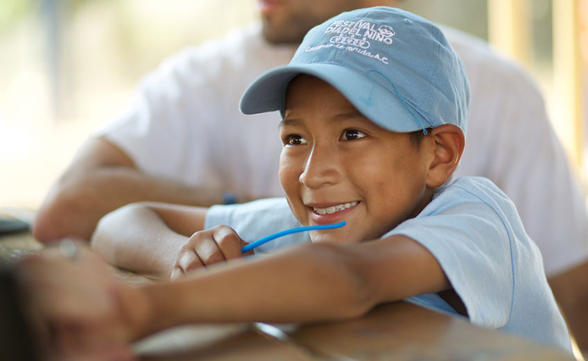 a smiling boy in a baseball cap