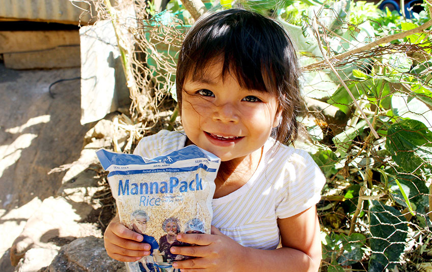 A girl holds a back of FMSC MannaPack Rice