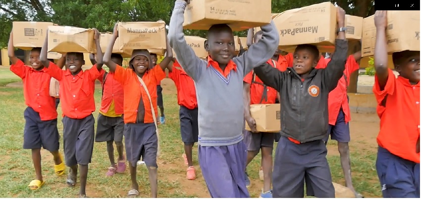 kids carrying boxes of FMSC food in Uganda
