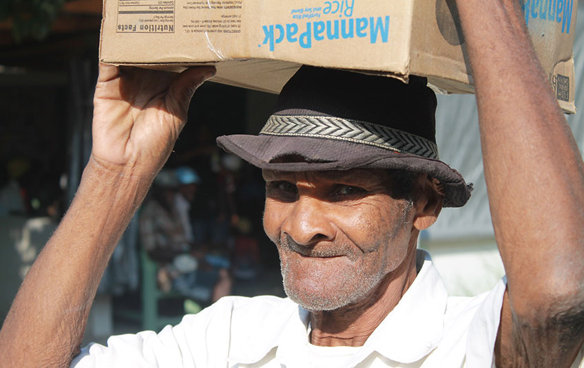a man carries a MannaPack box on his head
