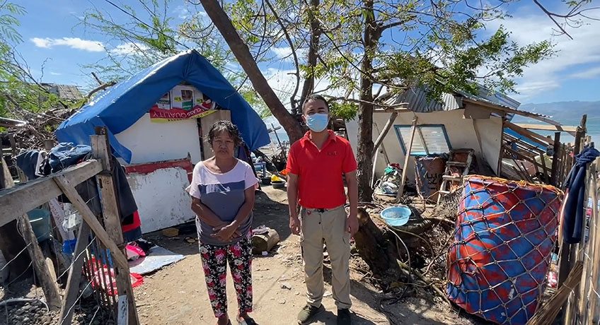 ICM staff with a Typhoon Rai survivor in the Philippines