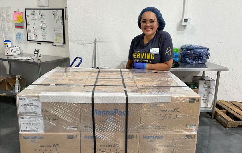 Cara Yavaliollah Monthly Giving Specialist with pallet of FMSC food