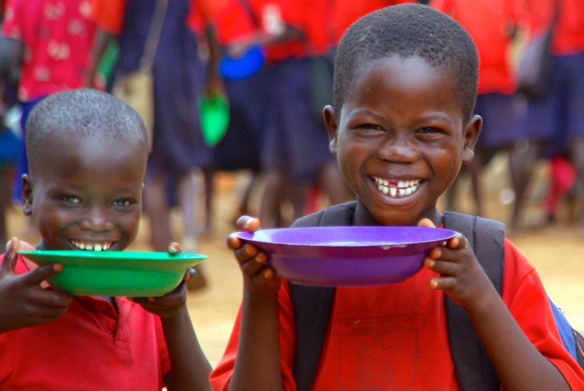 Two kids with bowls of FMSC food