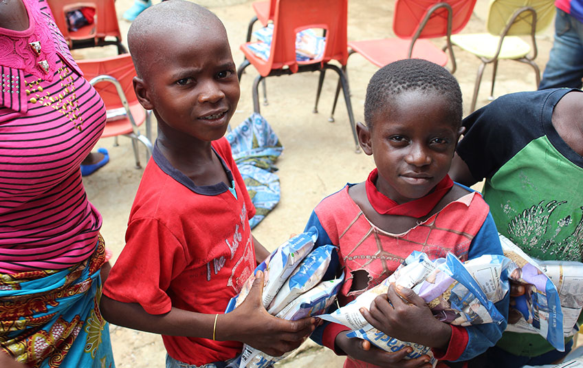 Children in Liberia holding FMSC food bags