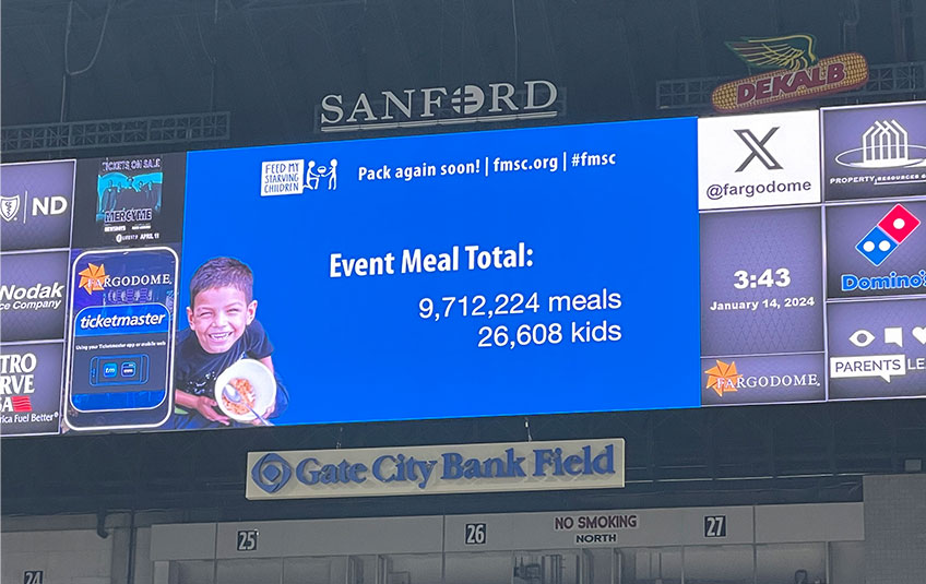 jumbotron displaying 9,712,224 meals packed and 26,609 children fed for a year