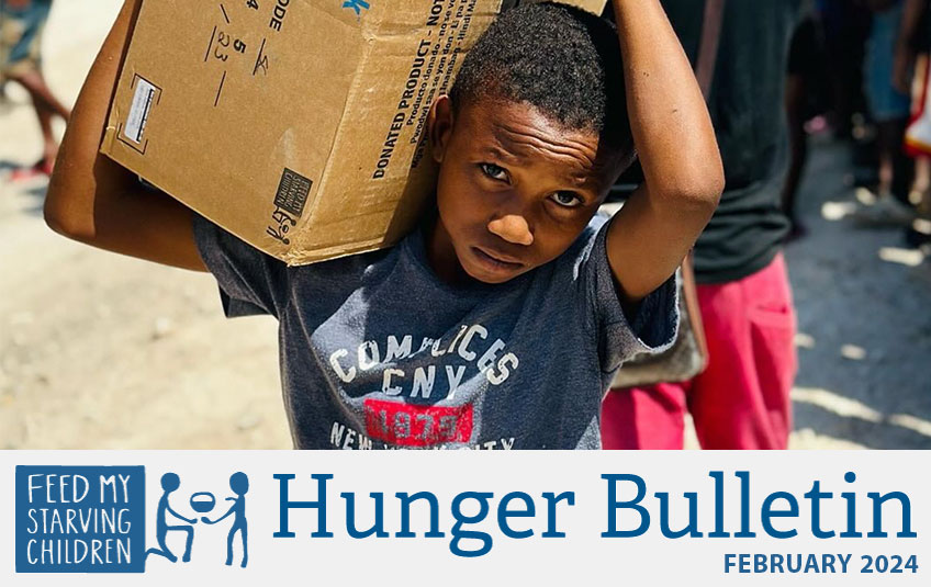 boy holding a box of FMSC food in Haiti with the text Hunger Bulletin February 2024 beneath
