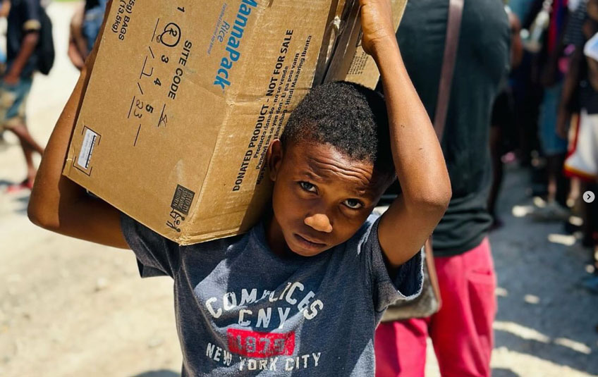 boy holding a box of FMSC food in Haiti