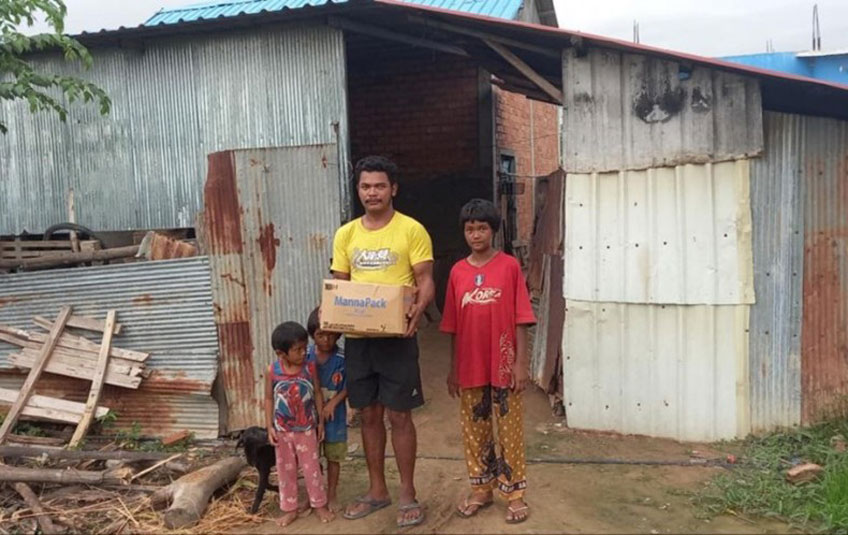 Cambodian family holding a box of FMSC food