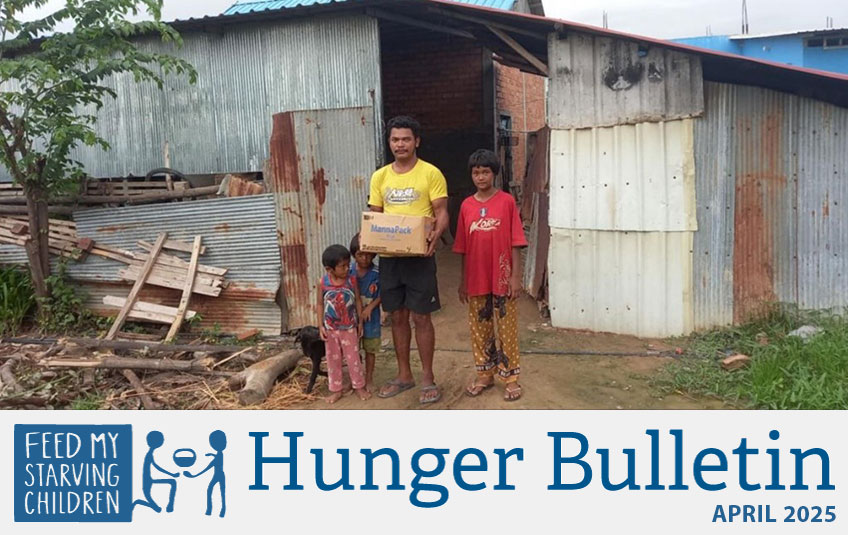 Cambodian family holding a box of FMSC food
