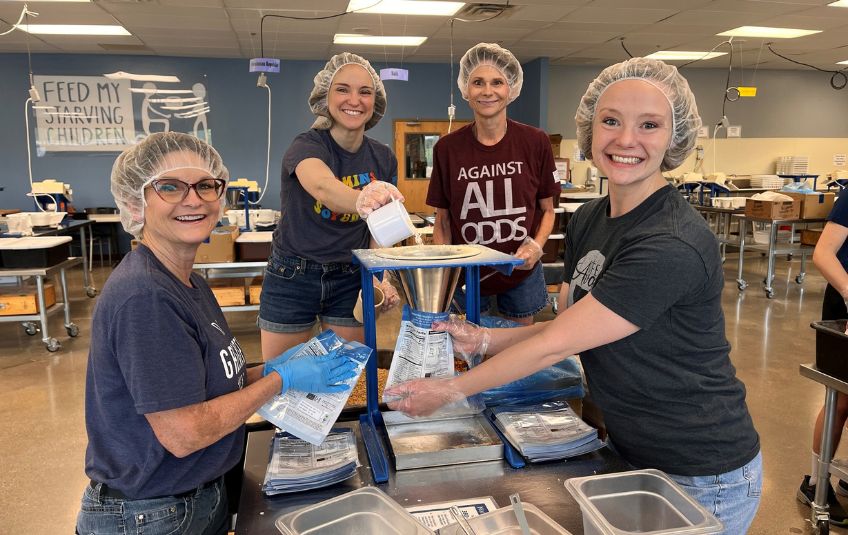 A group of women volunteering and packing meals.