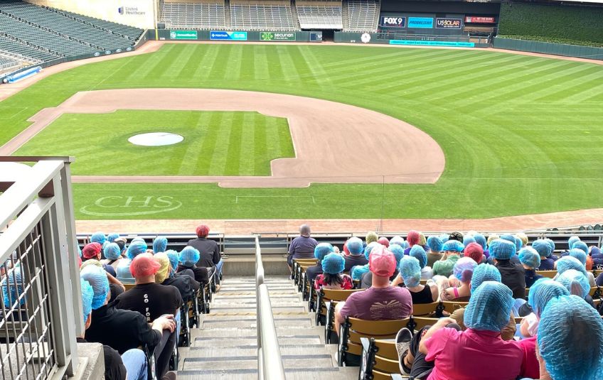Volunteers listening to instructions for Pack at the Park MobilePack at Target Field. 