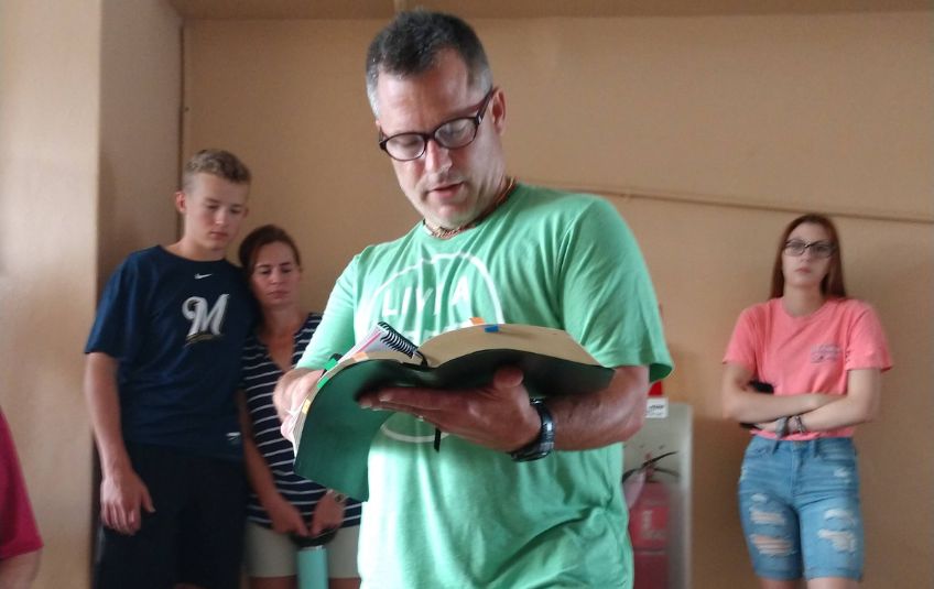 Troy Heller reading the Bible to a group.