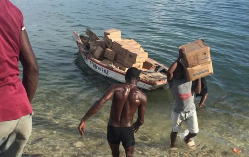 Men loading FMSC boxes on a small boat. 