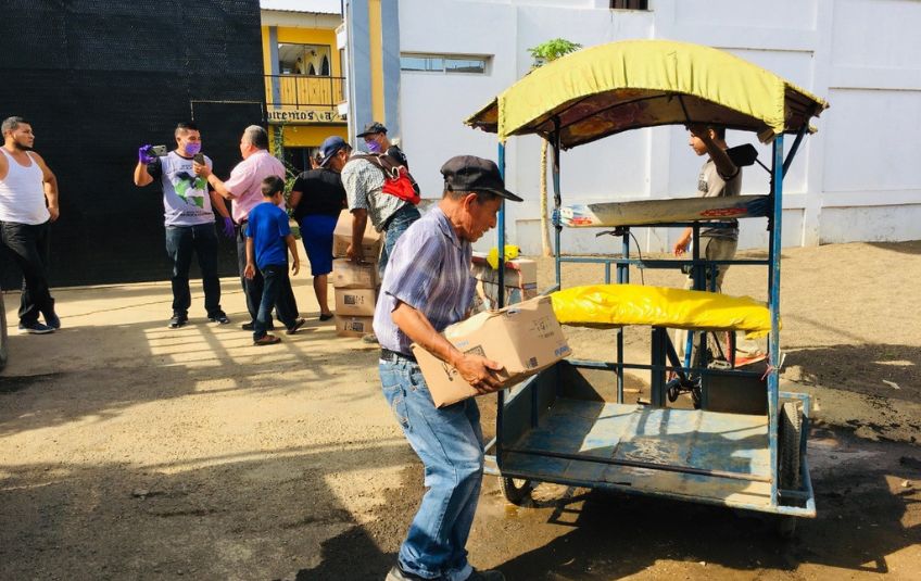 Man loading MannaPack box onto a wagon. 