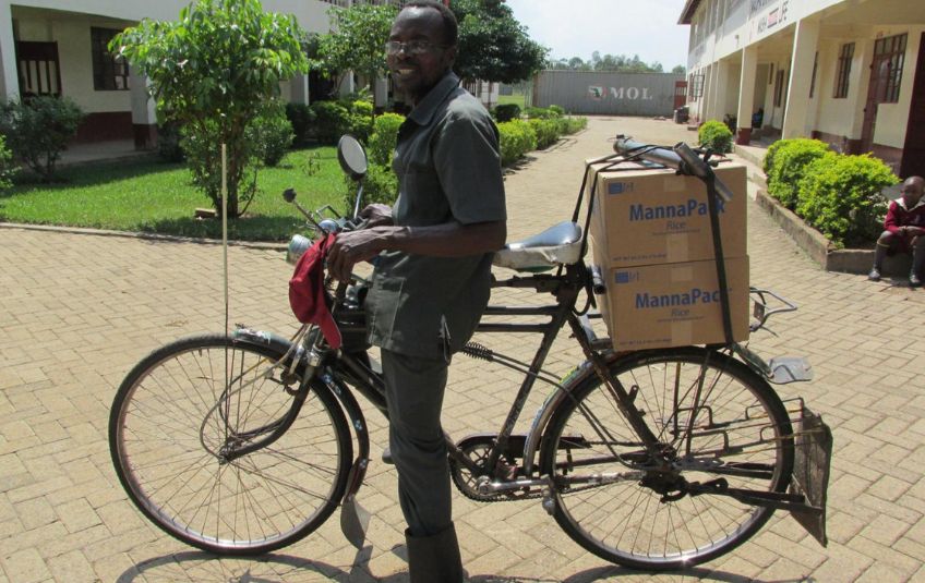 Man transporting MannaPack boxes by bike. 