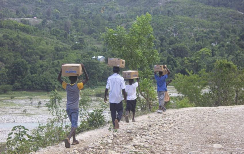 People hiking with MannaPack boxes on their heads. 