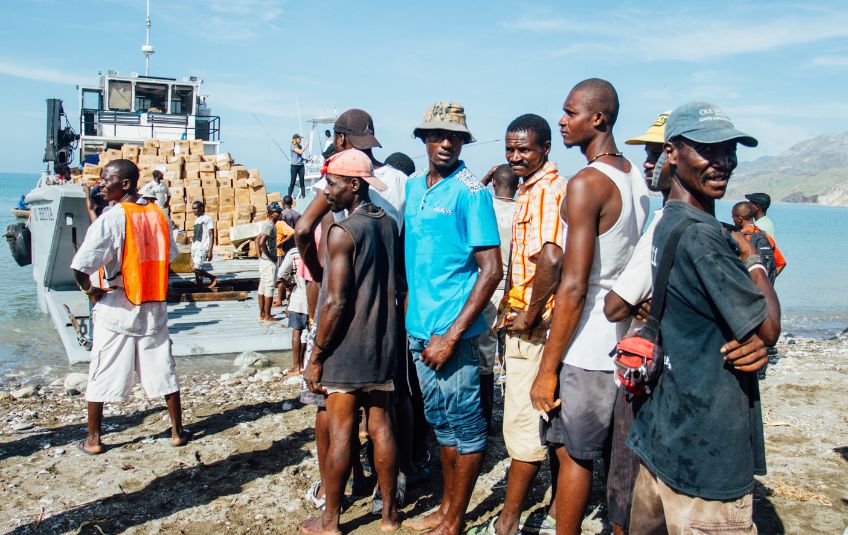 Partners loading MannaPack boxes on a boat. 
