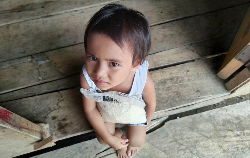 young girl with bag of rice looking up