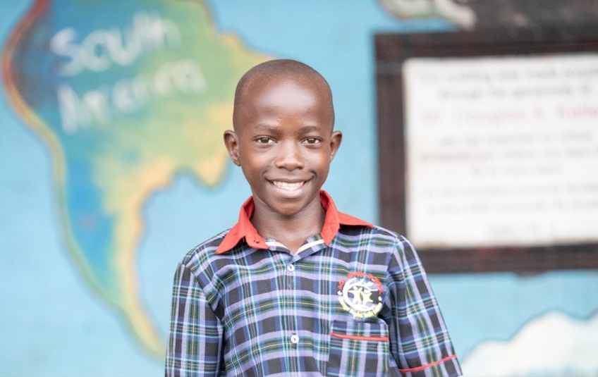 Teen Ugandan boy smiling in school uniform