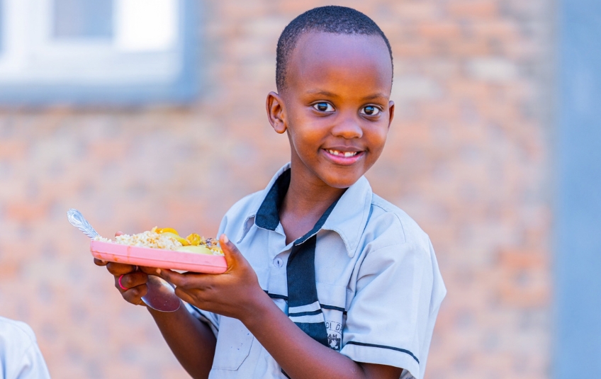 Young African boy smiling with plate of MannaPack Rice from nonprofit organization FMSC