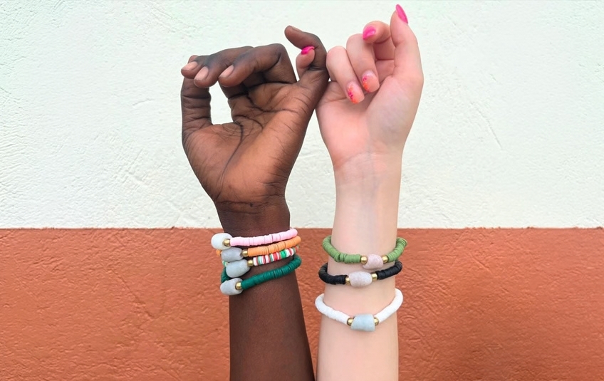 Dark and light skinned arms with handcrafted fair trade jewelry bracelets pinky promise