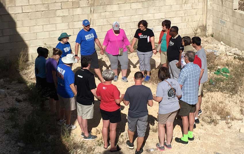 A group of FMSC staff and volunteers praying
