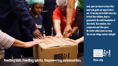 people praying over an FMSC box with FMSC's 2025 prayer verse on the side