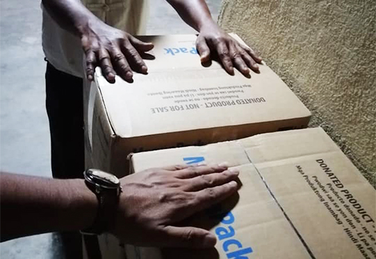 hands praying over MannaPack boxes