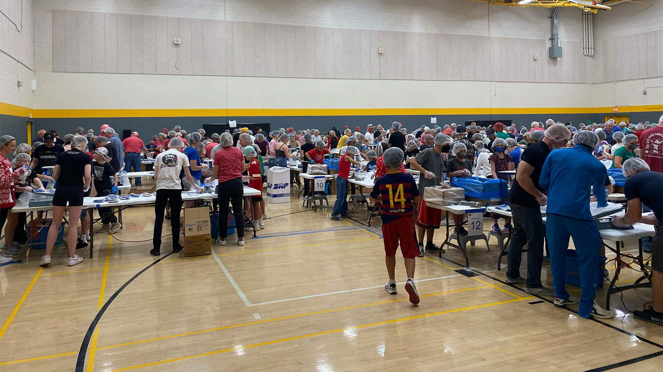 A gym full of volunteers packing meals at an FMSC event in Arizona