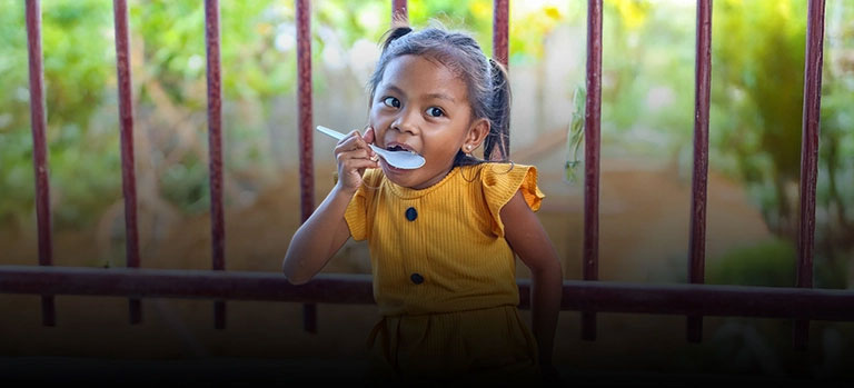A girl in the Philippines eats FMSC food