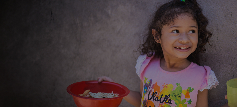 Girl holding a bowl of FMSC food